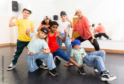 Group of children in casual clothes training hip-hop in class, posing and having fun
