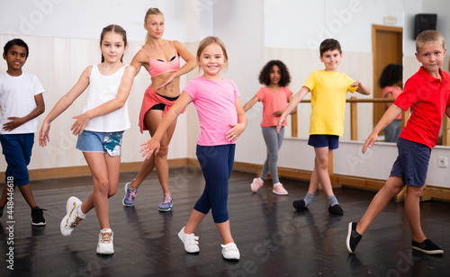 Group of children training in class, learning dance movements