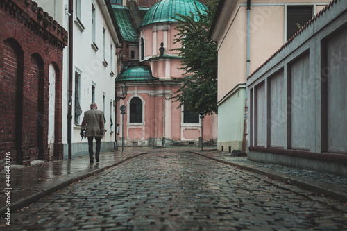man walking by the cobblestone street, old part of the city, Wroclaw, Poland © konrad hryciuk