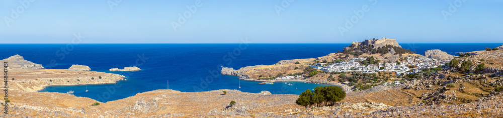 Lindos, with its ancient acropolis, ruins fortress and closed bays in sea coast, is the most view place of Rhodes island in Dodecanese, Greece. Vacation on Greece islands in Mediterranean sea.