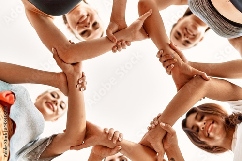 Group of young sporty girls with hands together.