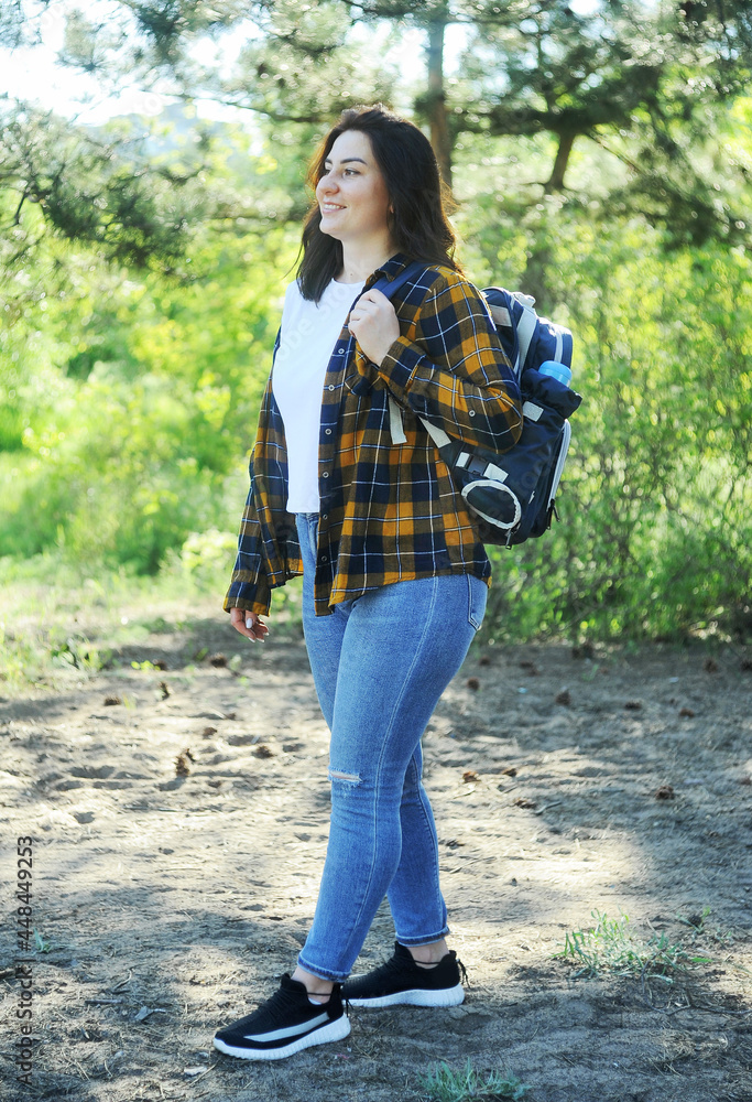 young woman with a bag spends time in the forest.
young woman with a bag spends time in the forest.