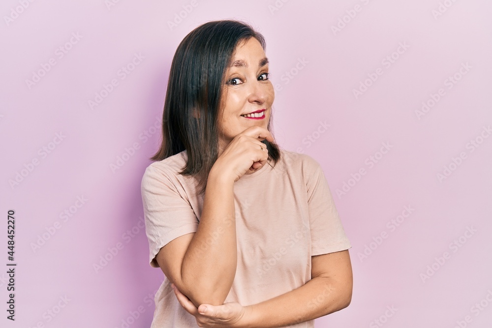 Middle age hispanic woman wearing casual clothes looking confident at the camera with smile with crossed arms and hand raised on chin. thinking positive. Middle age hispanic woman wearing casual clothes looking confident at the camera with smile with crossed arms and hand raised on chin. thinking positive.