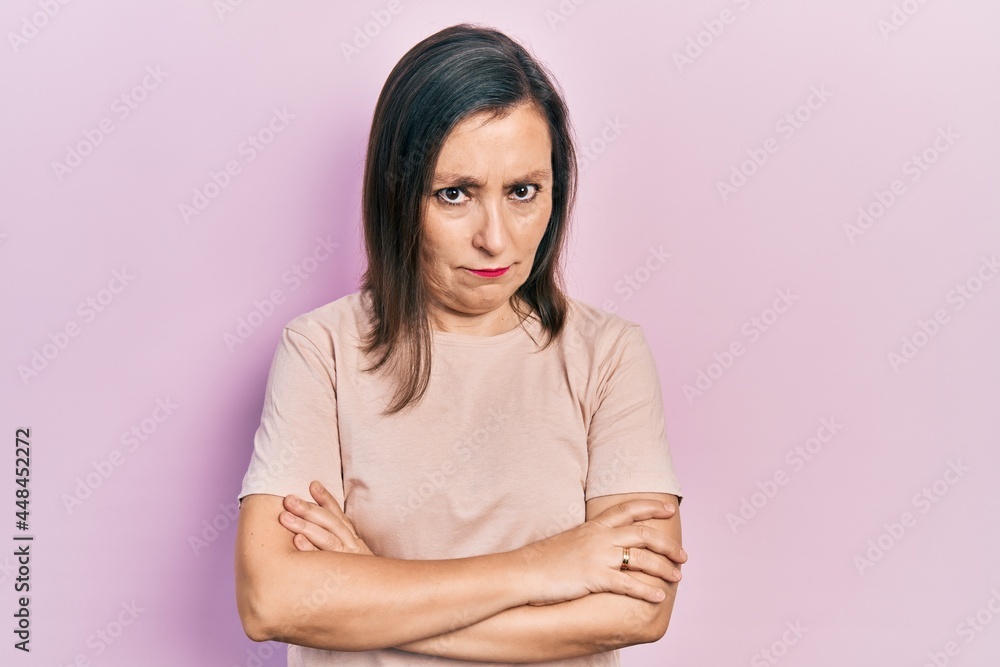 Middle age hispanic woman wearing casual clothes skeptic and nervous, disapproving expression on face with crossed arms. negative person. Middle age hispanic woman wearing casual clothes skeptic and nervous, disapproving expression on face with crossed arms. negative person.