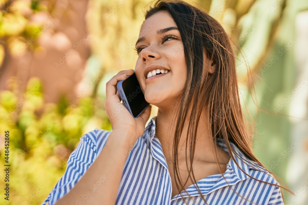 Young hispanic girl smiling happy talking on the smartphone at the city. Young hispanic girl smiling happy talking on the smartphone at the city.