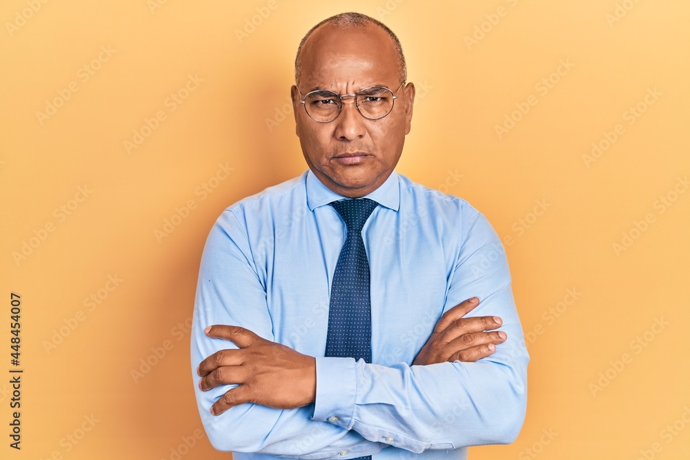 Middle age latin man wearing business clothes with arms crossed gesture clueless and confused expression. doubt concept. Middle age latin man wearing business clothes with arms crossed gesture clueless and confused expression. doubt concept.