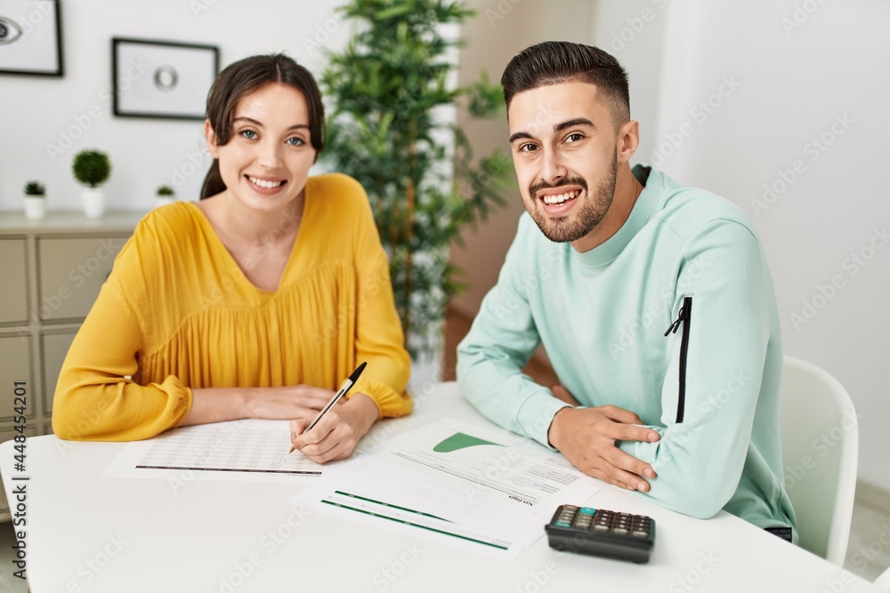 Young couple controlling family economy at home. Young couple controlling family economy at home.