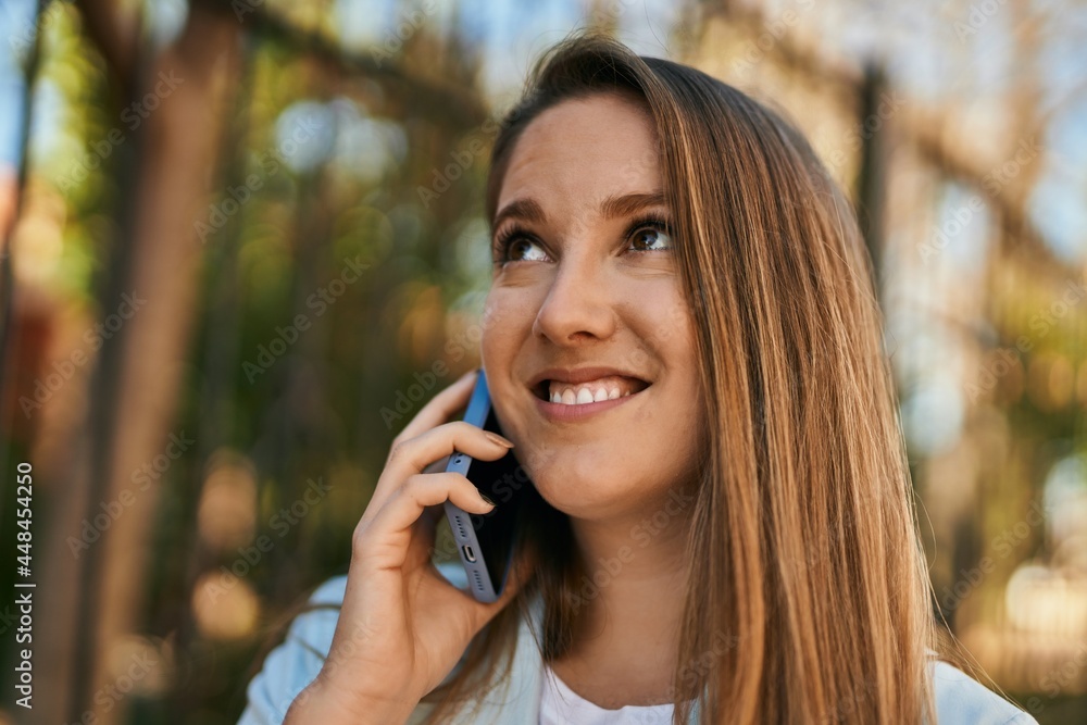 Young blonde businesswoman smiling happy talking on the smartphone at the city. Young blonde businesswoman smiling happy talking on the smartphone at the city.