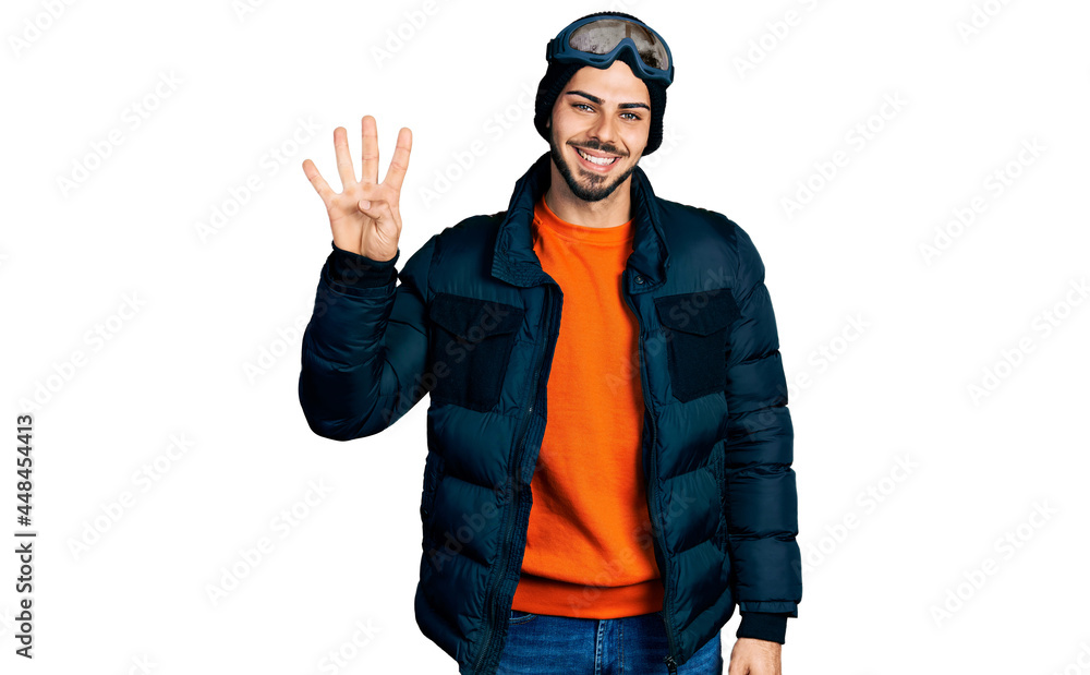 Young hispanic man with beard wearing snow wear and sky glasses showing and pointing up with fingers number four while smiling confident and happy. Young hispanic man with beard wearing snow wear and sky glasses showing and pointing up with fingers number four while smiling confident and happy.