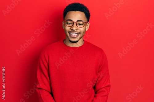 Young african american man wearing casual clothes and glasses with a happy and cool smile on face. lucky person.