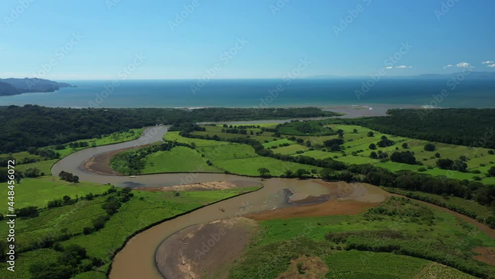 Muddy river tarcoles area agricultural green fields along the pacific ocean aerial Muddy river tarcoles area agricultural green fields along the pacific ocean aerial