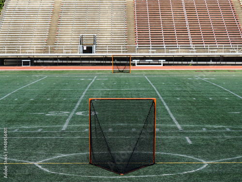 Empty Lacrosse goal nets await the start of play.  Stadium seating.