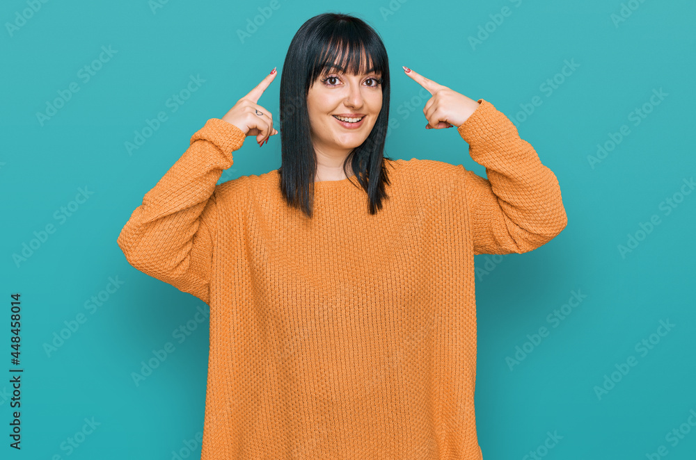 Young hispanic woman wearing casual clothes smiling pointing to head with both hands finger, great idea or thought, good memory Young hispanic woman wearing casual clothes smiling pointing to head with both hands finger, great idea or thought, good memory