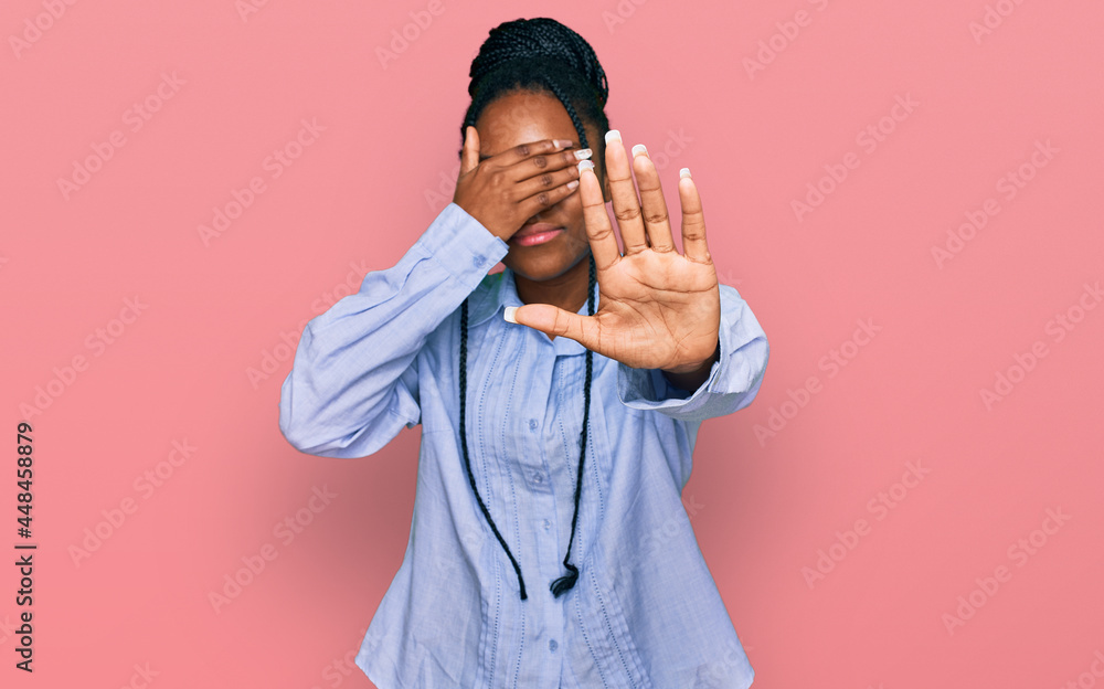 Young african american woman wearing casual clothes covering eyes with hands and doing stop gesture with sad and fear expression. embarrassed and negative concept. Young african american woman wearing casual clothes covering eyes with hands and doing stop gesture with sad and fear expression. embarrassed and negative concept.
