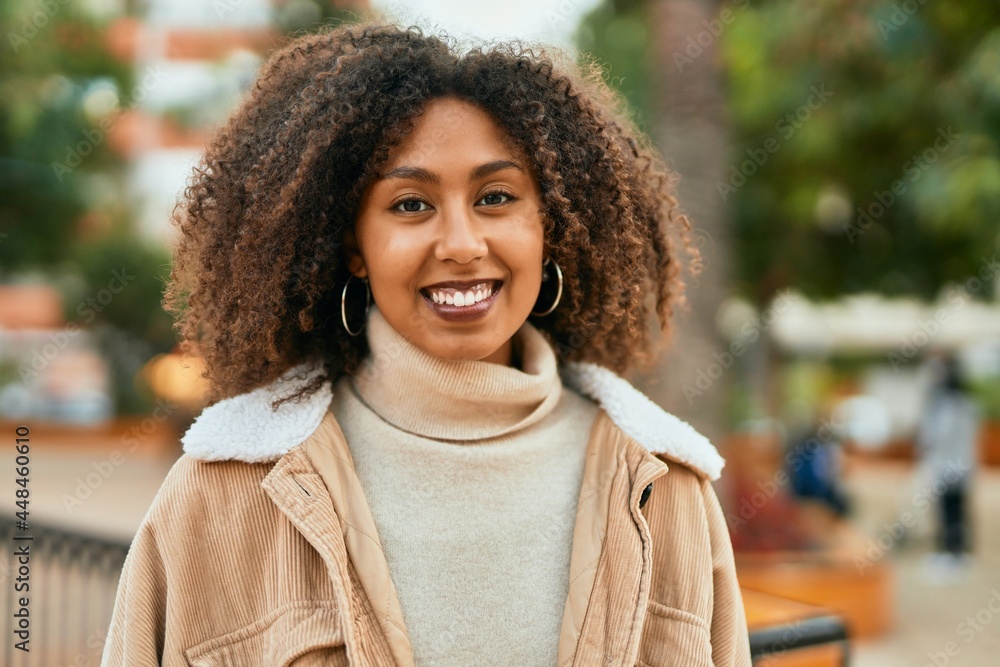 Young african american woman smiling happy standing at the park. Young african american woman smiling happy standing at the park.