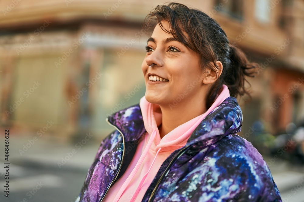 Young hispanic sporty woman smiling happy standing at the city.