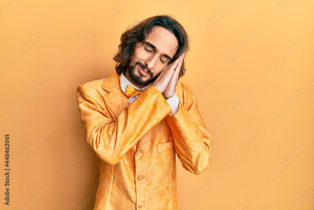 Young hispanic man wearing hipster elegant look sleeping tired dreaming and posing with hands together while smiling with closed eyes. Young hispanic man wearing hipster elegant look sleeping tired dreaming and posing with hands together while smiling with closed eyes.
