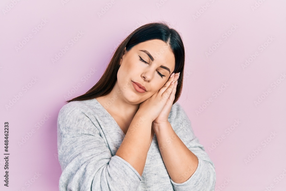 Young hispanic woman wearing casual clothes sleeping tired dreaming and posing with hands together while smiling with closed eyes. Young hispanic woman wearing casual clothes sleeping tired dreaming and posing with hands together while smiling with closed eyes.