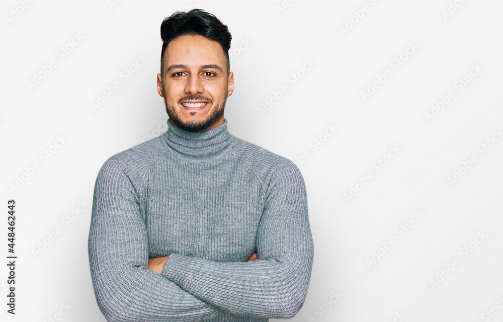 Young arab man wearing casual clothes happy face smiling with crossed arms looking at the camera. positive person. Young arab man wearing casual clothes happy face smiling with crossed arms looking at the camera. positive person.
