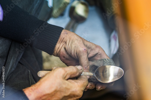 local craftman worker is making bronze fork and spoon tableware