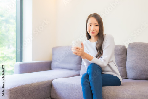 Portrait beautiful young asian woman with coffee cup on sofa