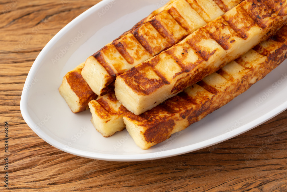 Grilled Rennet or Coalho cheese on a white plate Grilled Rennet or Coalho cheese on a white plate
