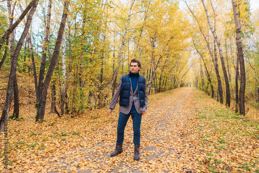 Tall handsome man walking in the autumn alley Tall handsome man walking in the autumn alley