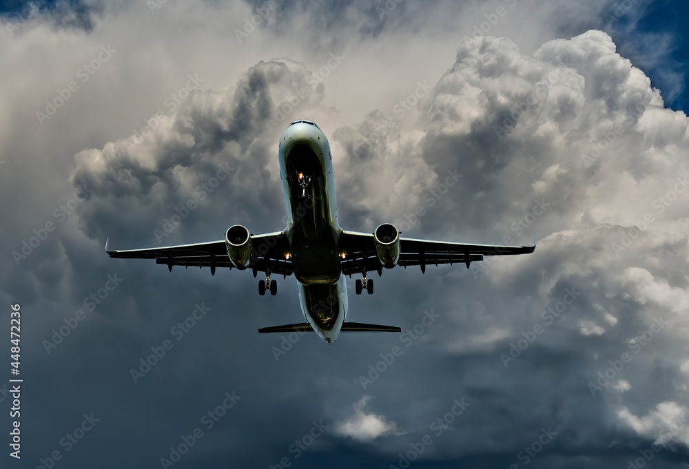 Obraz premium Landing airplane among thunderstorm clouds. Concept of travel and transportation