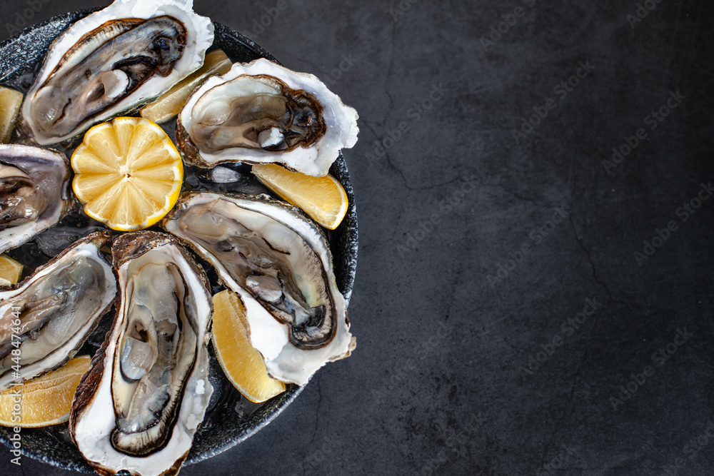 Opened oysters on plate with Lemon and ice Opened oysters on plate with Lemon and ice