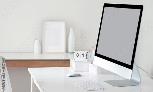 Mockup blank screen monitor on white table. © NAMPIX