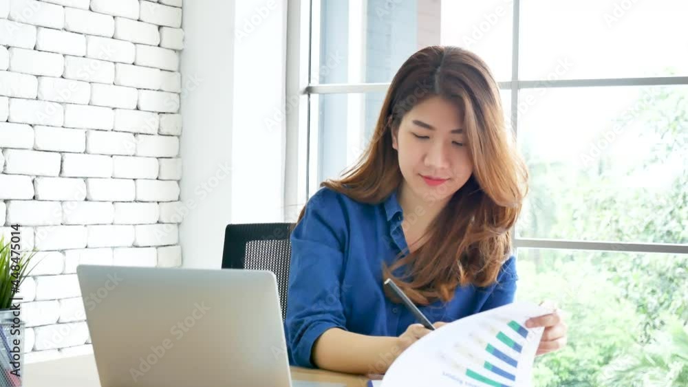 Happiness Asian Woman working from home using laptop online meeting in home office. Happy relax time asian business woman typing keyboard use notebook laptop Smiling, laughing at home office. Happiness Asian Woman working from home using laptop online meeting in home office. Happy relax time asian business woman typing keyboard use notebook laptop Smiling, laughing at home office.