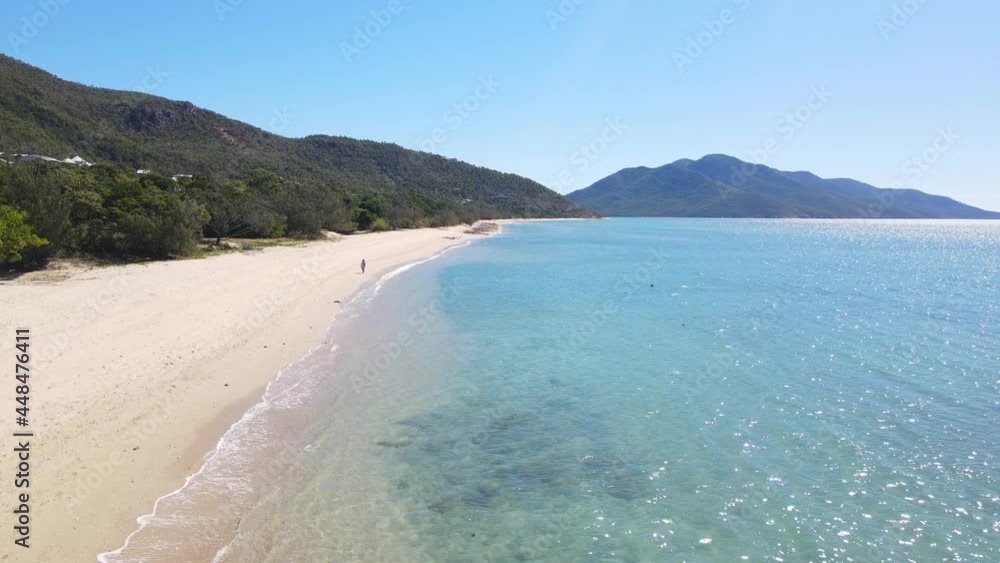 Female Tourist Wandering At The Seashore Of Hydeaway Bay Beach In North Queensland, Australia. aerial Female Tourist Wandering At The Seashore Of Hydeaway Bay Beach In North Queensland, Australia. aerial