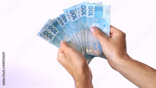 A man showing a range of 100 reais bills on white background photo