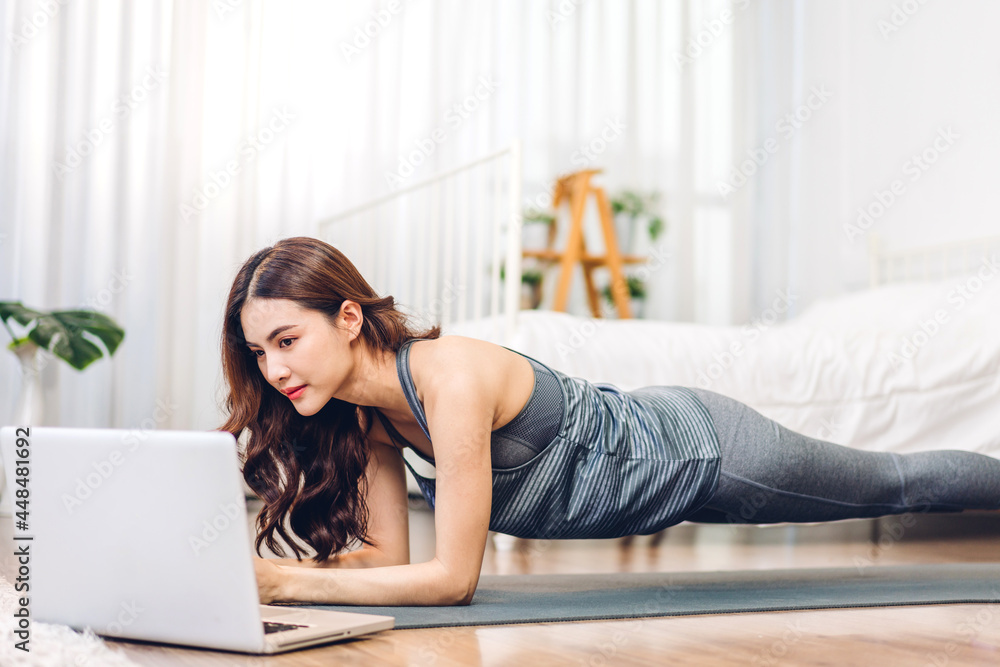 Portrait sport asian beauty body slim woman in sportswear sitting relax and girl practicing yoga and do fitness exercise with laptop computer in bedroom at home.Diet concept.Fitness and healthy Portrait sport asian beauty body slim woman in sportswear sitting relax and girl practicing yoga and do fitness exercise with laptop computer in bedroom at home.Diet concept.Fitness and healthy