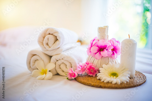 Towel and compress, Decorated with a pink flower. Spa composition on massage table.