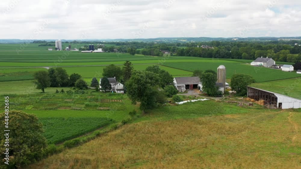 Aerial orbit of rural farm in USA. American farming community with green fields in summer. Aerial orbit of rural farm in USA. American farming community with green fields in summer.