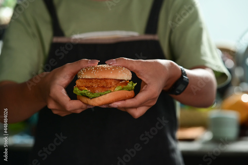 Woman holding homemade burgers in hands.