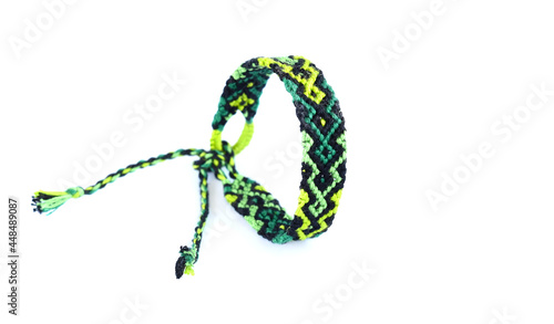 Woven DIY friendship bracelets handmade of embroidery bright thread with knots on white background.