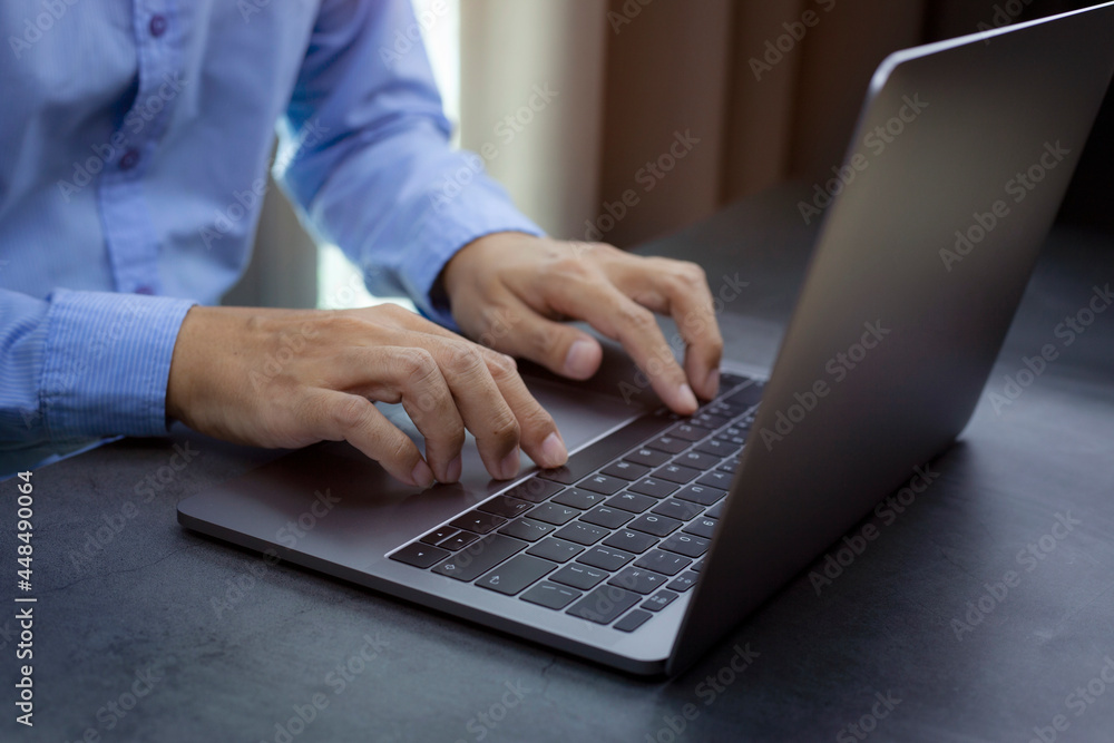 Businessman working at the table with laptop, hands typing on computer keyboard, researching new business strategy. Businessman working at the table with laptop, hands typing on computer keyboard, researching new business strategy.