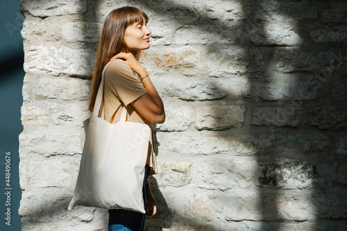 Woman holding black canvas tote bag. Bag mockup for design.