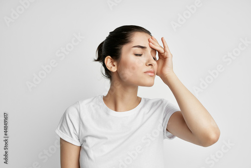 Fotografie woman in white t-shirt emotion displeasure headache health problems