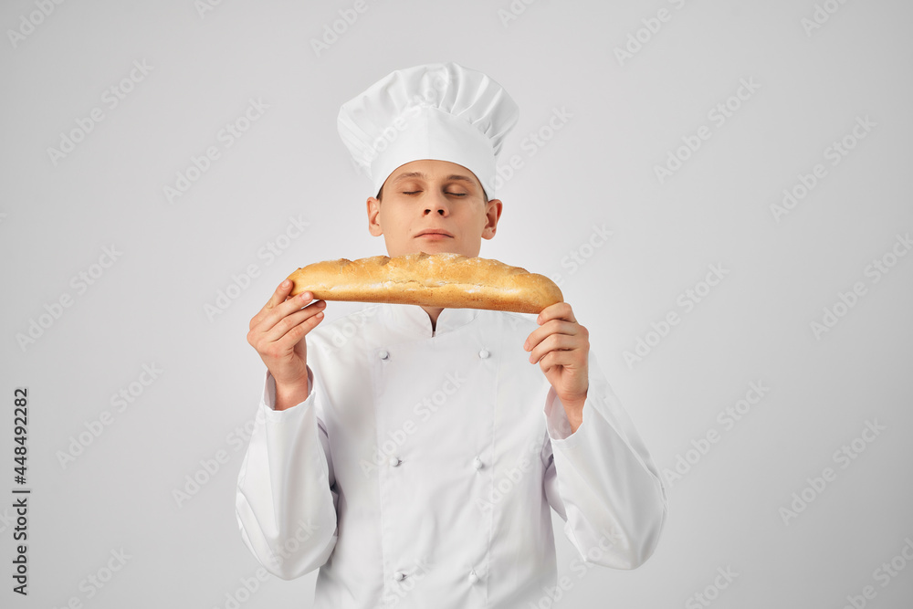 a man in chef's clothes looking at a loaf professional bakery industry a man in chef's clothes looking at a loaf professional bakery industry
