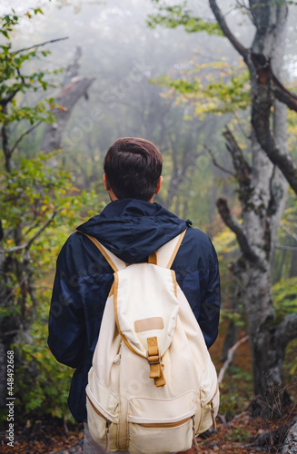 young man traveler in autumn misty nature. rear view. concept active healthy lifestyle, adventure and travel vacation