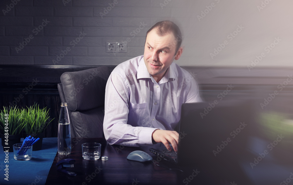 man at table and working on laptop