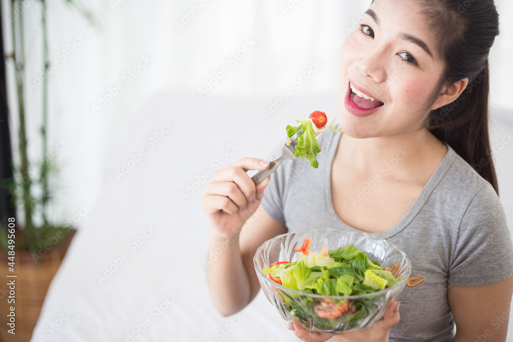 Enjoyed Asian woman eating vegetable salad. Enjoyed Asian woman eating vegetable salad.