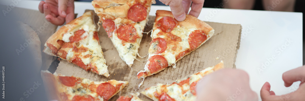 Group of people taking slices of pizza closeup Group of people taking slices of pizza closeup