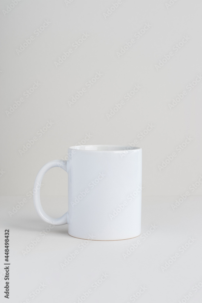 Fototapeta premium Single white mug on light gray background, mockup