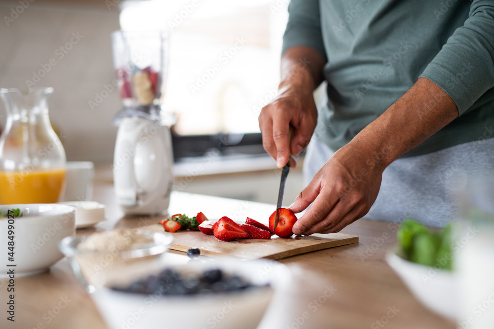 Unrecognizable man preparing smoothie indoors at home, healthy diet concept.