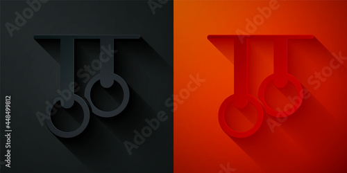 Paper cut Gymnastic rings icon isolated on black and red background. Playground equipment with hanging rope with rings. Paper art style. Vector