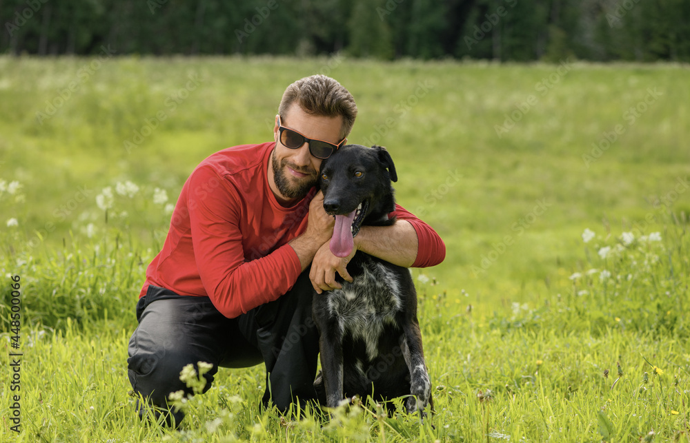 Caucasian man, 30 years old, is hugging his happy dog in outdoors. Caucasian man, 30 years old, is hugging his happy dog in outdoors.